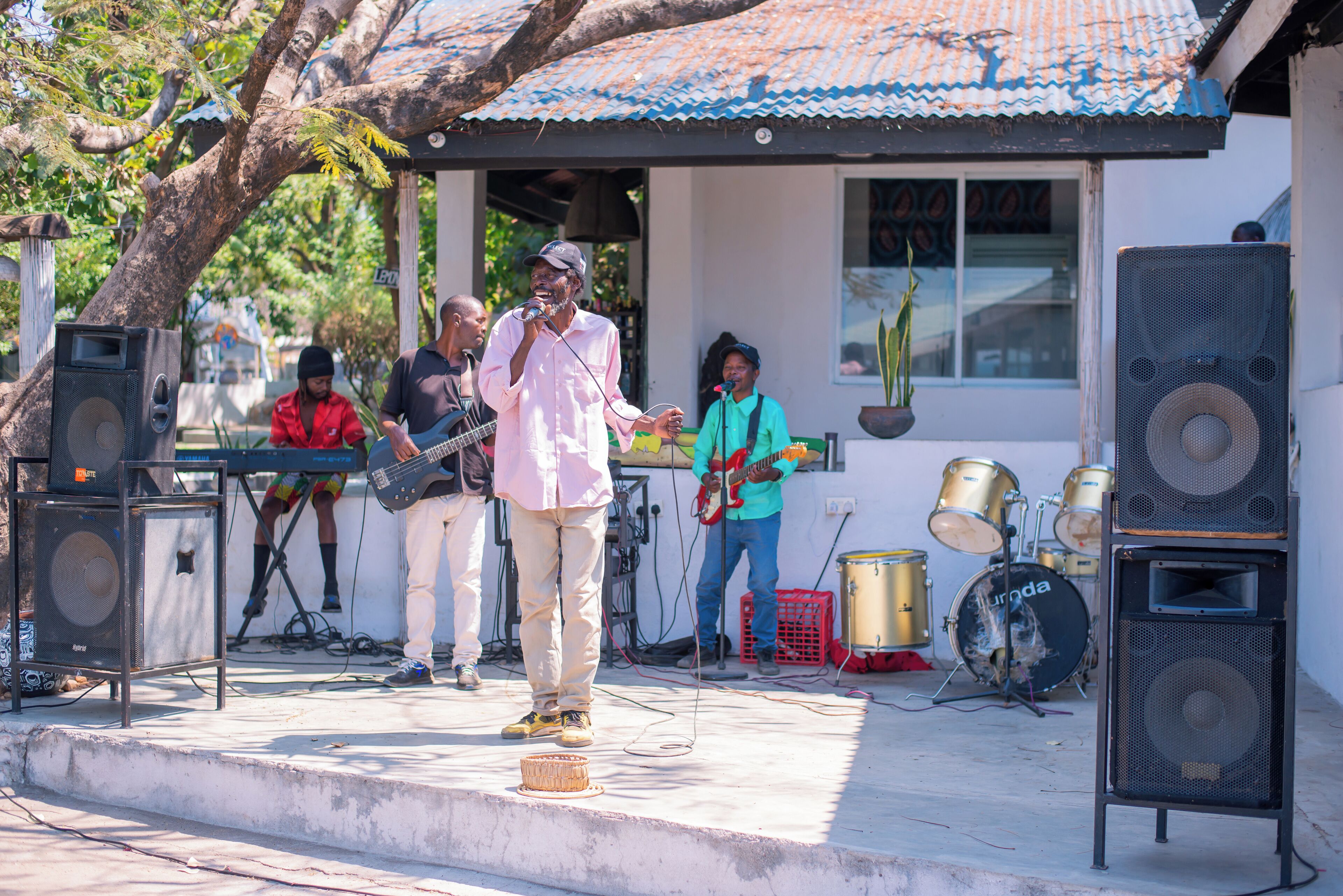 Uma banda se apresentando ao ar livre, com instrumentos musicais e caixas de som.