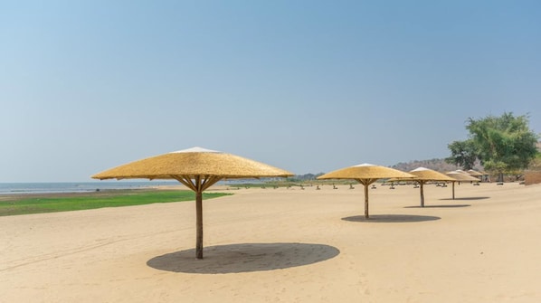 Privatstrand, weißer Sandstrand, Sonnenschirme