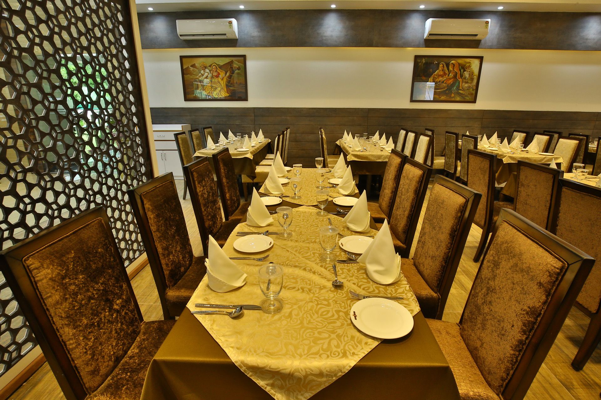 A formal dining room with a long table set for a meal, surrounded by chairs.