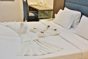 Un lit bien fait, avec du linge de lit blanc et des arrangements floraux décoratifs.