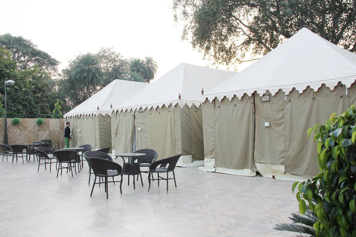 A series of tents with tables and chairs arranged in an outdoor setting.