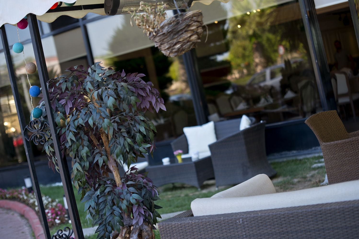 An outdoor seating area with wicker furniture and a decorative plant.