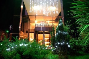 A modern hotel with a glass facade, a balcony, and string lights. - North Point Hotel (Samsun)