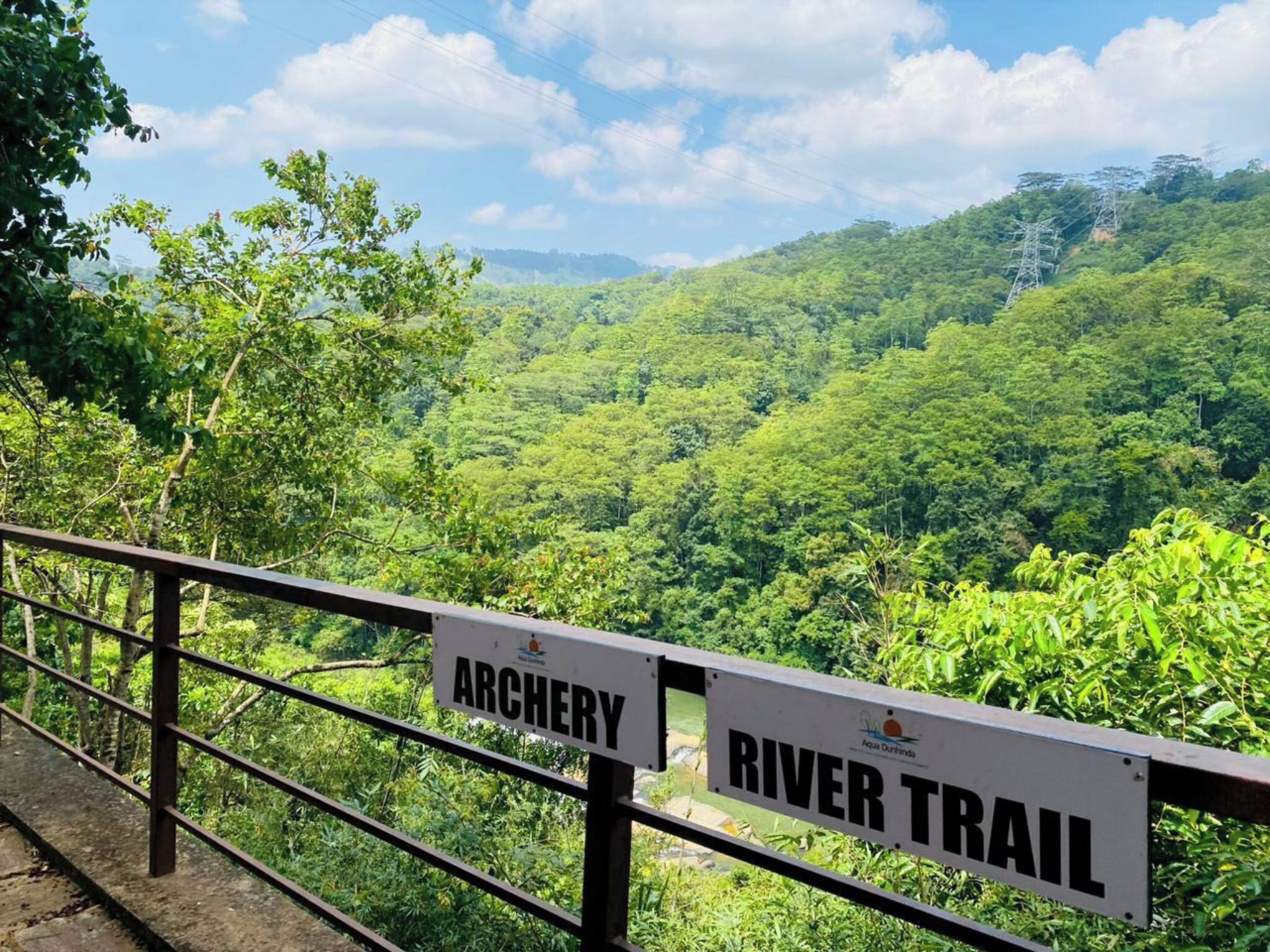 A sign indicating an archery area and a river trail.