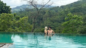 A swimming pool with clear water, surrounded by lush greenery and hills in the background. - Aqua Dunhinda Villa & Nature Retreat (Kandy)
