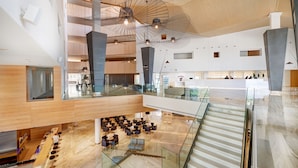 A spacious lobby with a high ceiling, modern lighting fixtures, and a central staircase. - Hipotels Gran Playa de Palma (Palma de Mallorca)