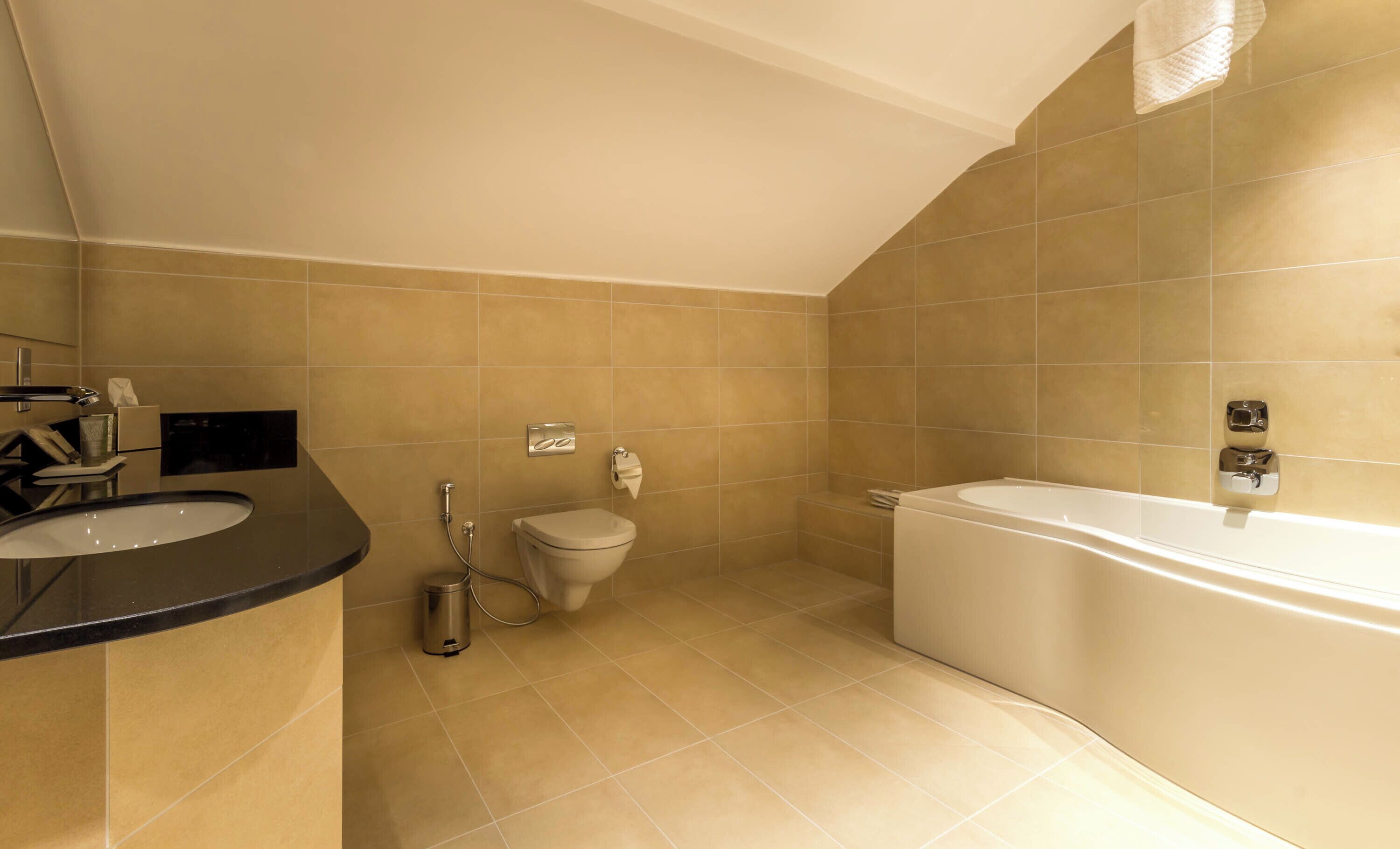 A modern bathroom with a bathtub, toilet, and sink.