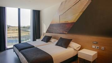Une chambre d’hôtel avec deux lits, une grande fenêtre et vue sur la plage.