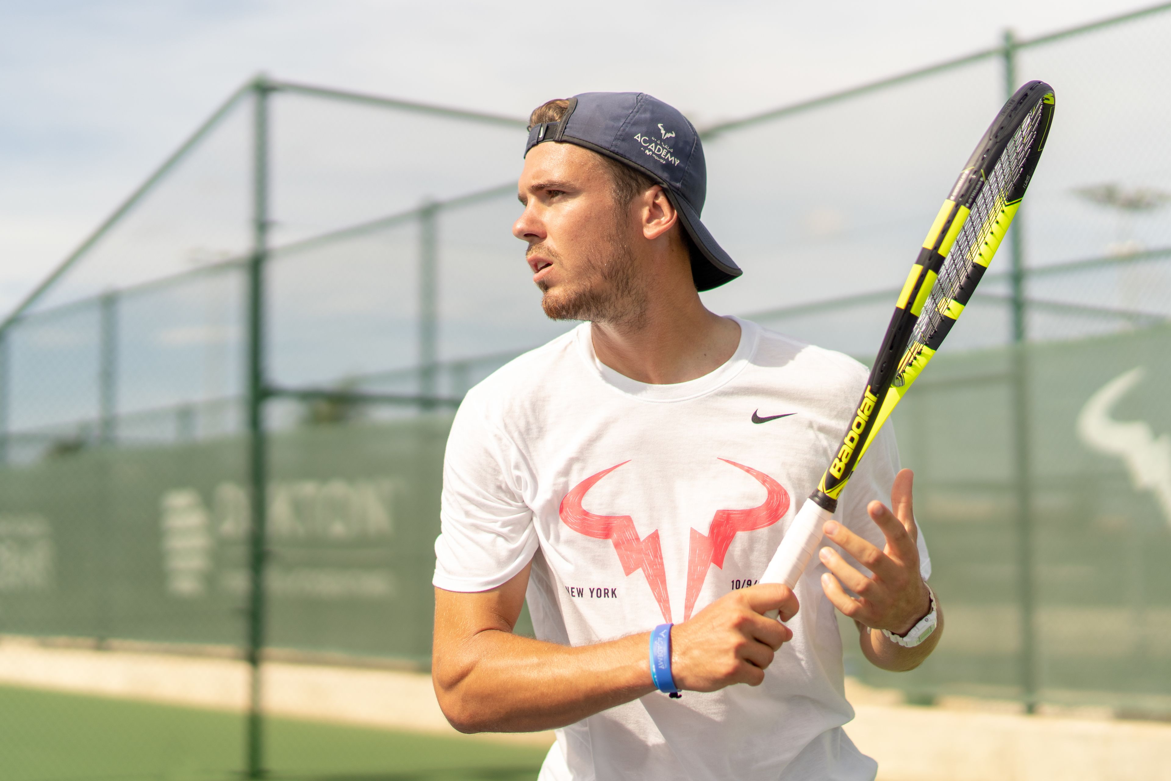 Une personne tenant une raquette de tennis sur un court de tennis.
