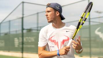 Une personne tenant une raquette de tennis sur un court de tennis.