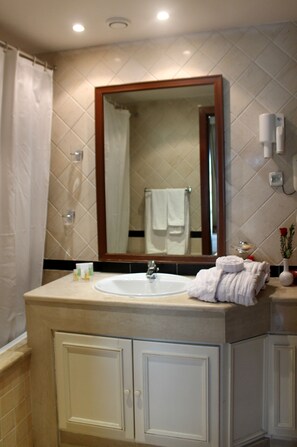 A bathroom with a sink, mirror, and cabinets. - Hôtel Le Consul (Tunis)