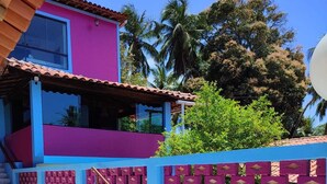 A staircase leading to a pink and blue building with a tiled roof. - Pousada Vila Anaua (Japaratinga)