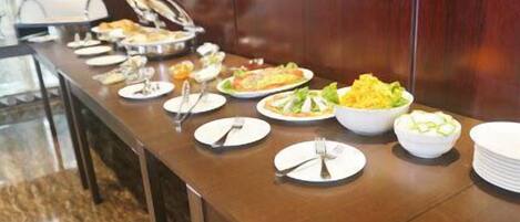 A buffet table with various dishes and utensils.