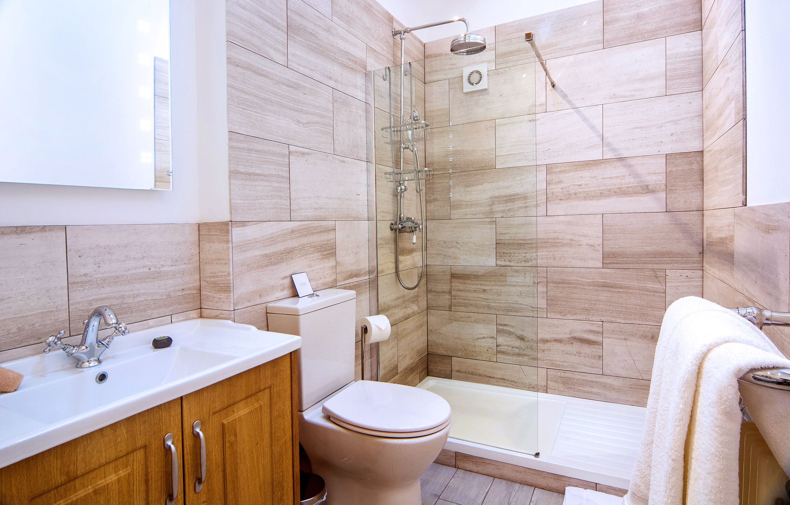 A modern bathroom with a shower, toilet, sink, and bathtub.