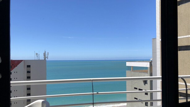 Un balcón con vista al mar y edificios.