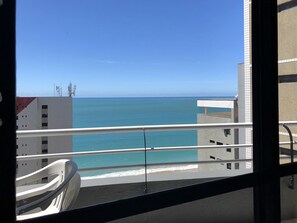 A balcony with a view of the sea and buildings.