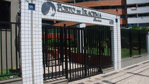 Entrada porticada al hotel Porto de Iracema, con fachada de azulejos y un cartel sobre la entrada.