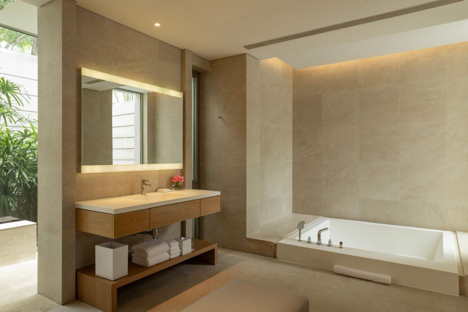 Une salle de bain moderne avec un grand miroir, un lavabo et une baignoire.