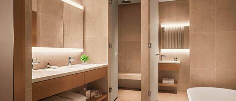 A modern bathroom with a large mirror, two sinks, a shower, and a bathtub.
