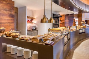 Zona de bufé con diferentes opciones de comida y una estación de café.