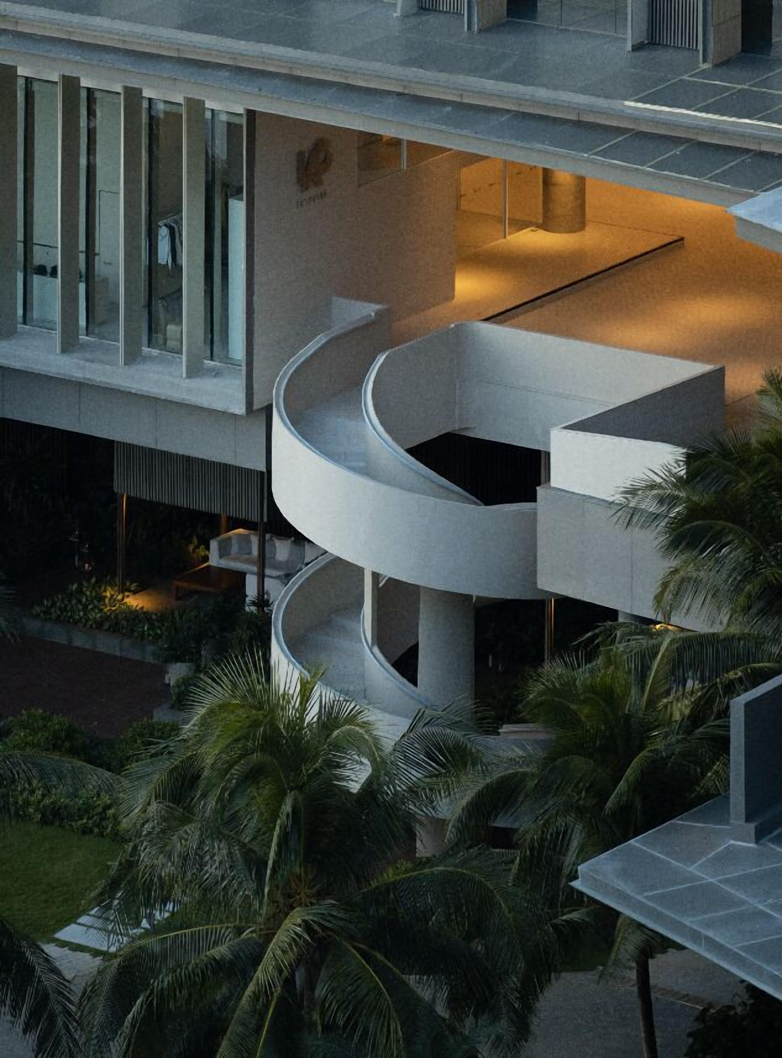 Un bâtiment moderne doté d’un balcon incurvé et d’un espace piscine.
