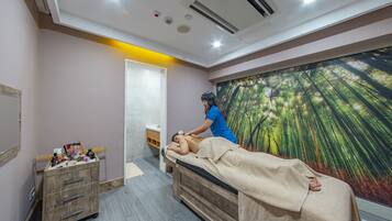 Relax in a serene space with a massage therapy bed and soothing forest mural.