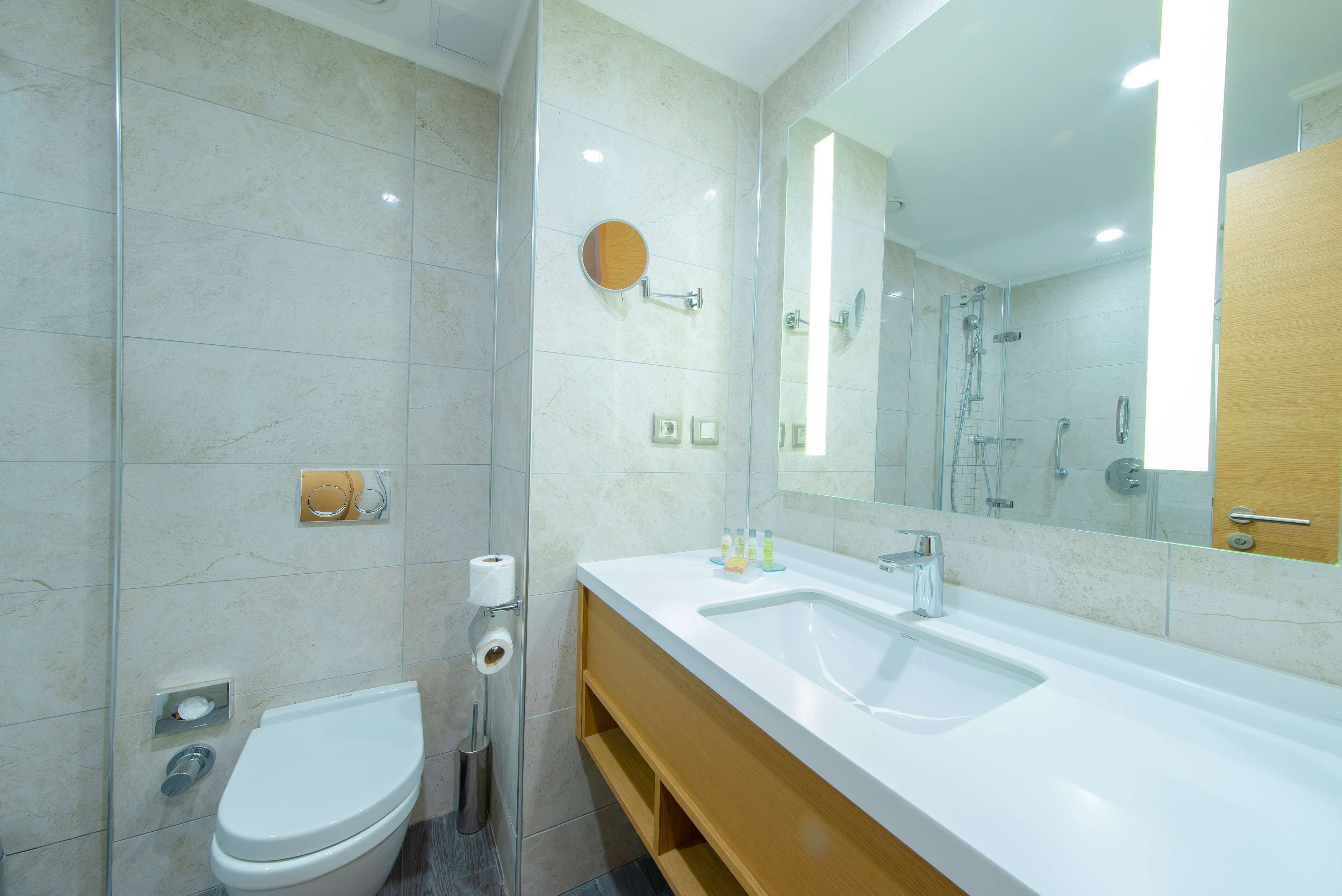 A modern bathroom with a toilet, sink, and shower.
