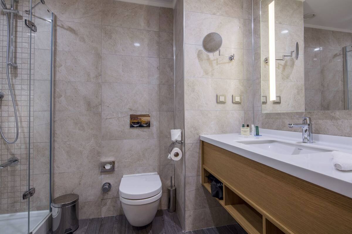 A modern bathroom with a shower, toilet, and vanity.