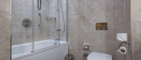 Un baño moderno con ducha de vidrio, una bañera blanca, inodoro y un cubo de basura.