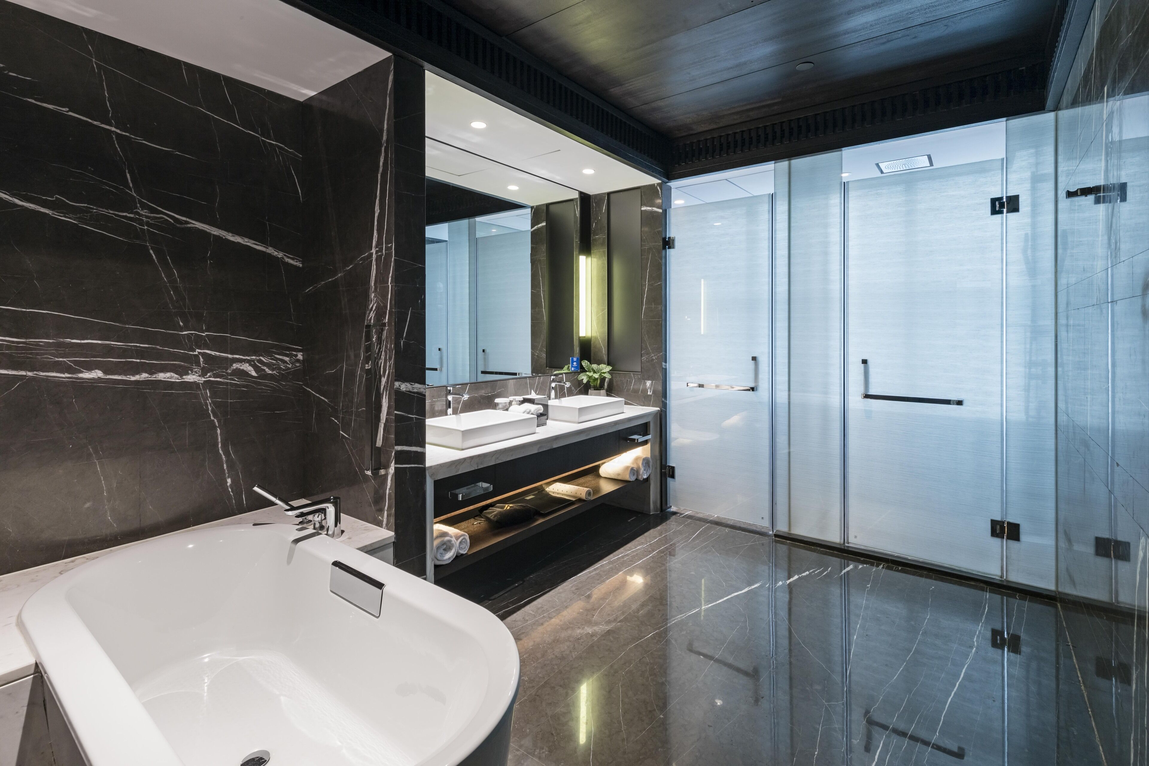 A modern bathroom with a large bathtub, a vanity with a mirror, and a walk-in shower.