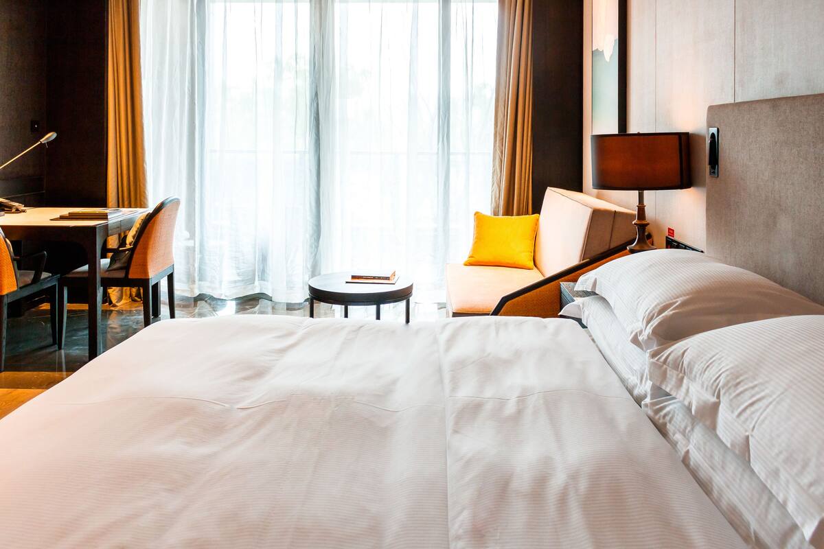 Una habitación de hotel con una cama grande, un escritorio y una silla.