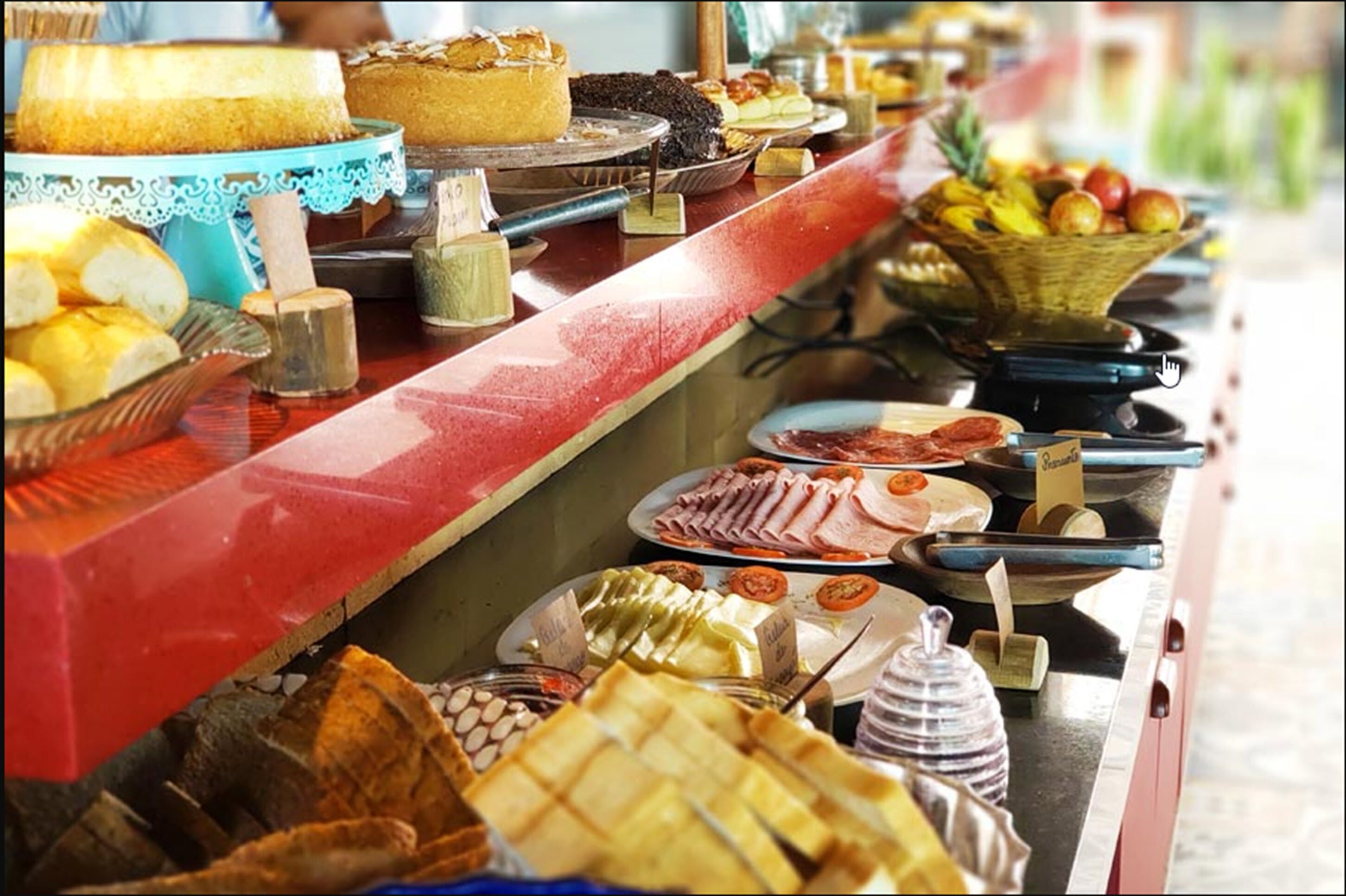 A buffet with various food items including bread, pastries, and fruits.