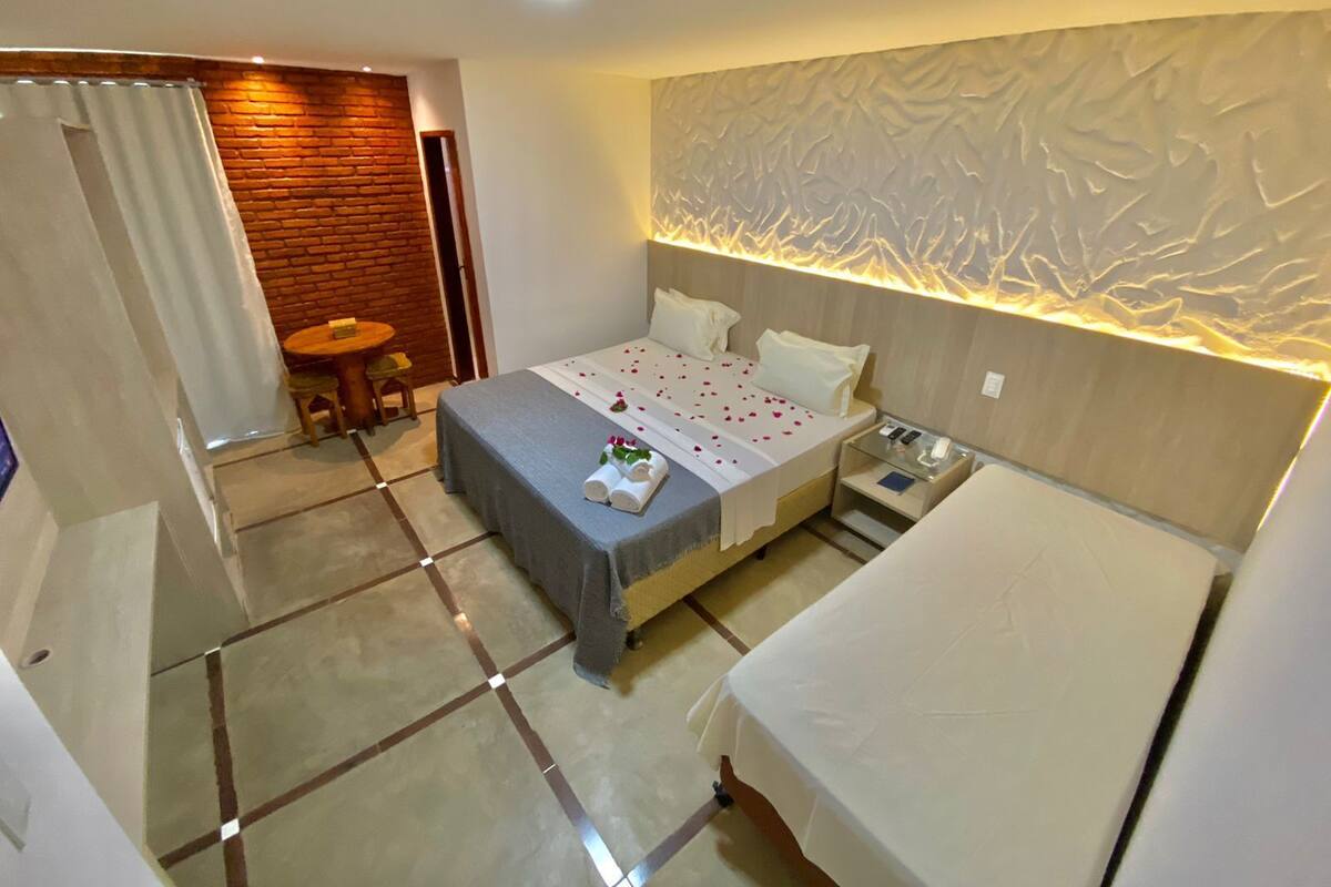 Una habitación de hotel con una cama, una mesita y una silla.