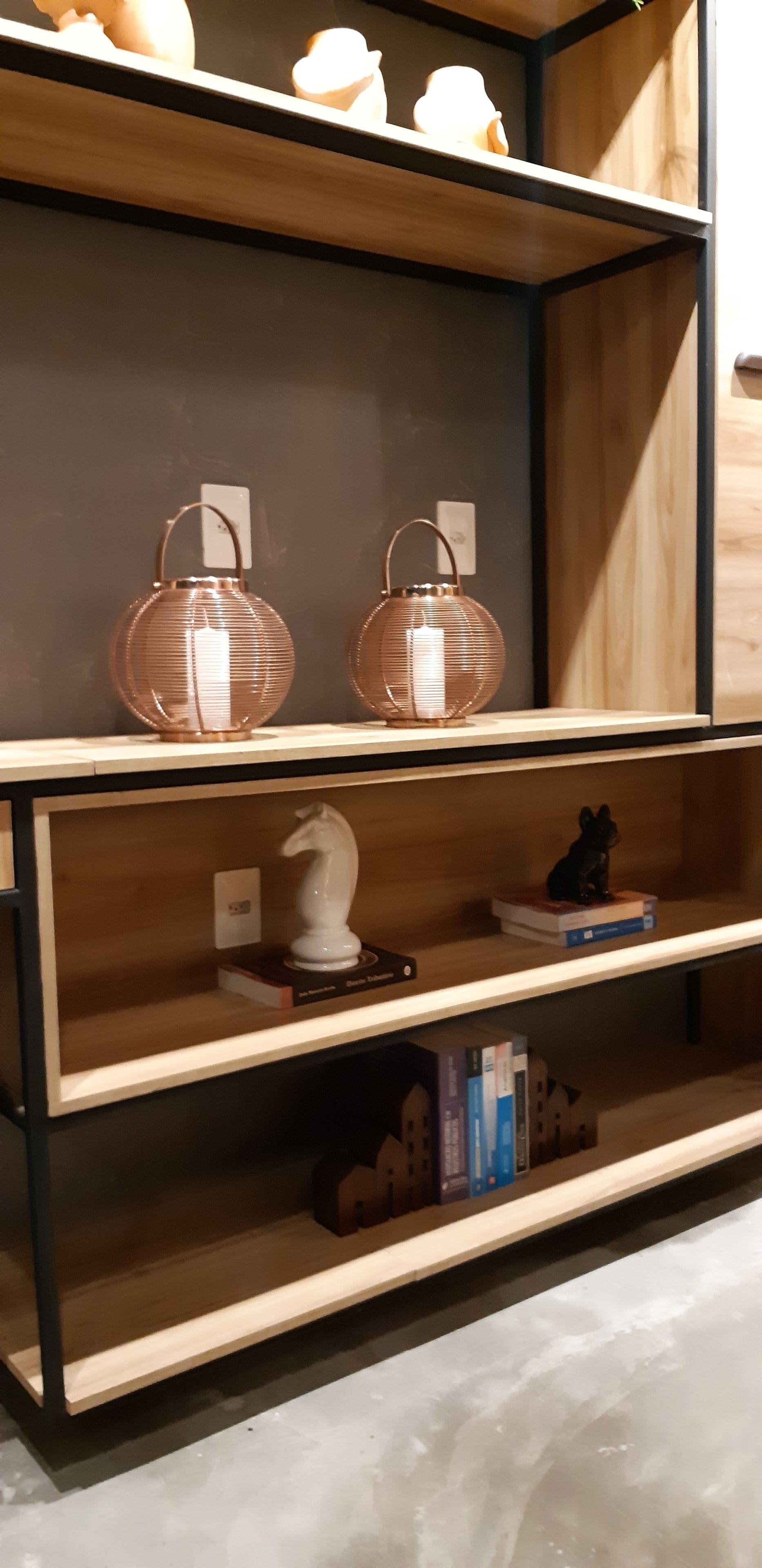 A wooden shelf with decorative items, including two spherical objects and a small figurine.