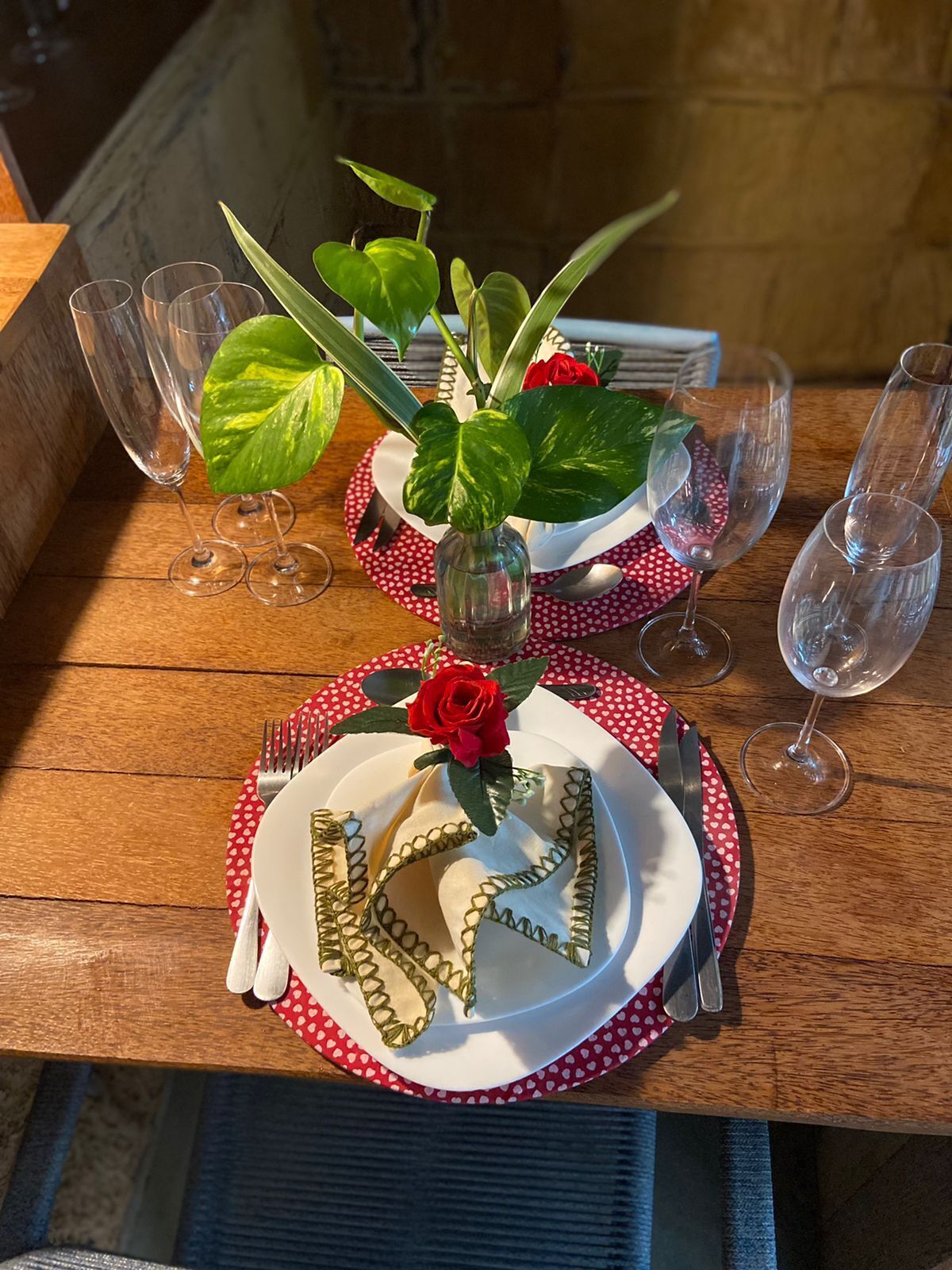 Une table dressée avec de l’argenterie blanche, des serviettes à pois rouges et blancs, et des verres à vin transparents.