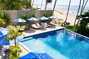Una piscina al aire libre, sillones reclinables de piscina
