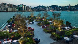A rooftop terrace with outdoor seating, greenery, and a city skyline view. - Kerry Hotel Hong Kong by Shangri-la (Kowloon)