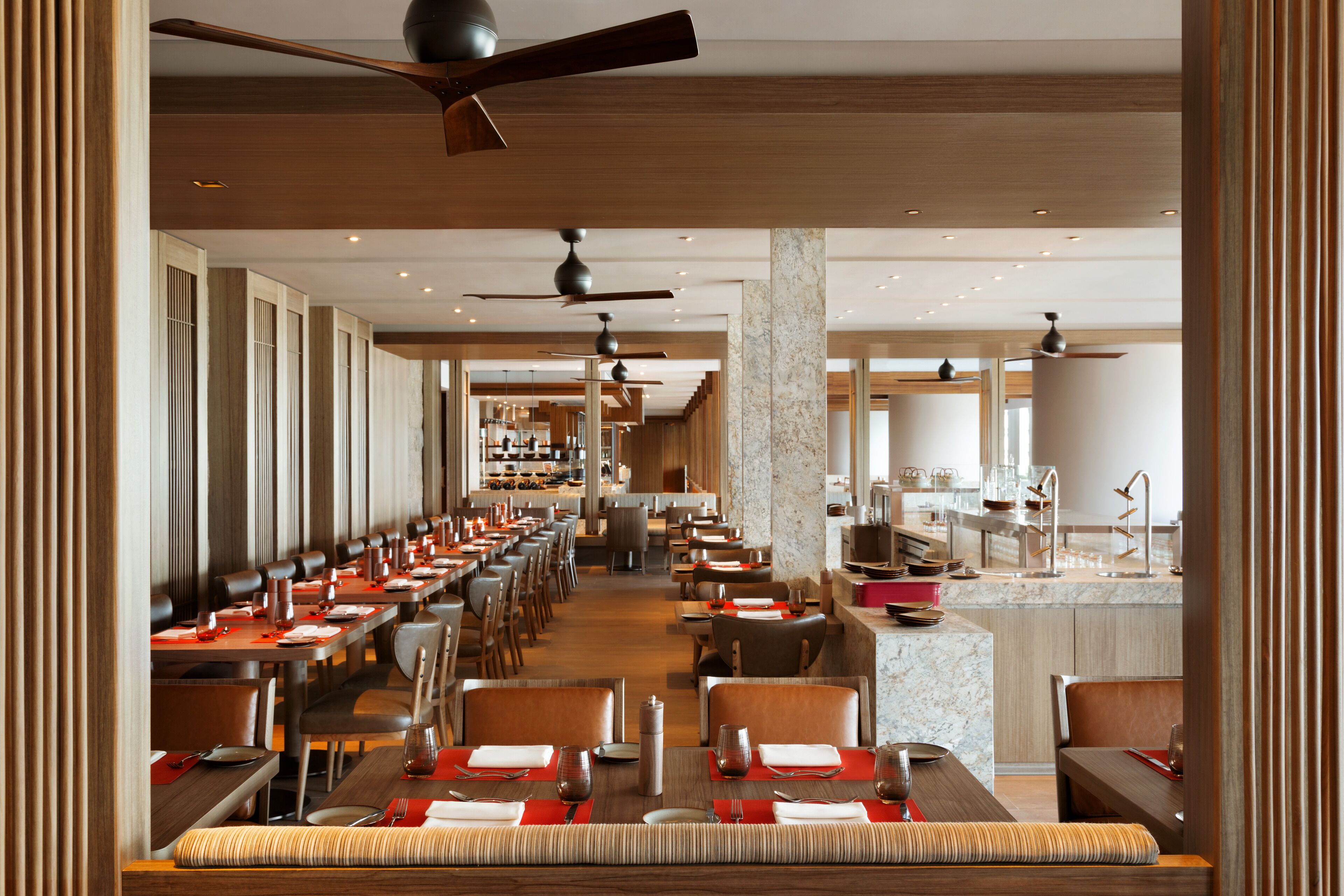A spacious restaurant with multiple dining areas, high ceilings, and modern lighting fixtures.