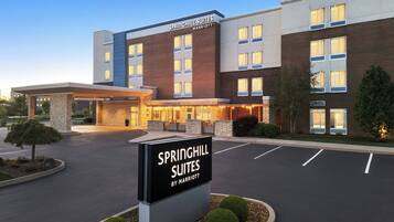 A hotel with a sign reading 'SPRINGHILL SUITES BY MARRIOTT,' a brick facade, and a parking lot.