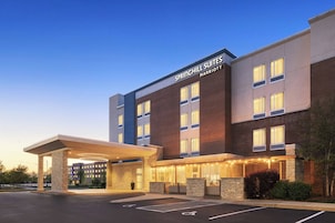 Un hotel con entrada cubierta, varios pisos y un letrero que dice 'SPRINGHILL SUITES MARRIOTT'.