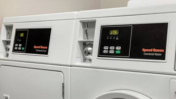 Duas máquinas de lavar roupa industriais, marca Speed Queen, com mostradores digitais.