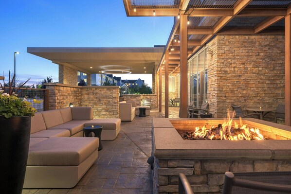 Un patio al aire libre con una chimenea, asientos y paredes de piedra.
