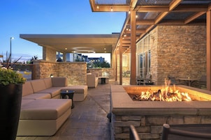 Un patio al aire libre con una chimenea, asientos y paredes de piedra.