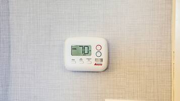 Ein Thermostat an einer strukturierten Wand.