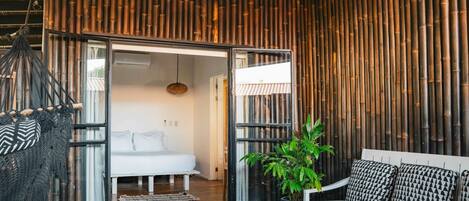 Un interior moderno con cama, sofá y planta colgante.
