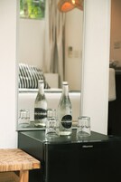 Un refrigerador Hisense negro con varias botellas y vasos vacíos encima.