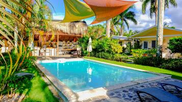 Una piscina al aire libre, sillones reclinables de piscina