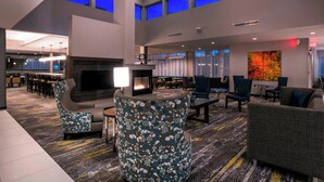 A spacious lobby with a fireplace, comfortable seating, and a large TV screen. - Residence Inn by Marriott Fishkill (Fishkill)