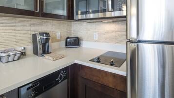 Una cocina moderna con electrodomésticos de acero inoxidable, lavavajillas y tostadora.