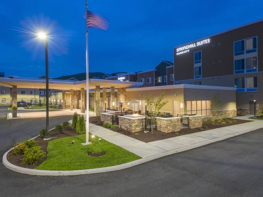 A hotel entrance with a flag, outdoor seating, and a Marriott sign.